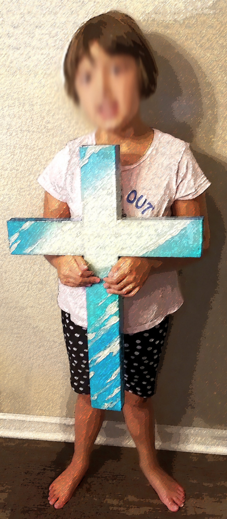 Child holding a handmade blue painted wooden cross